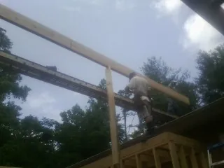 Carpenter setting a ridge beam over a new addition frame — Ice Dam Removal by Roofing Brothers in Morgan